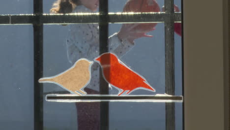 child looking at birds on stained glass window