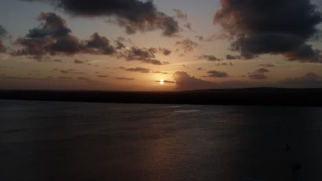 trucking right aerial shot of a golden sunset from the famous alligator beach, a river in cabedelo, paraiba, brazil, near the coastal capital city of joao pessoa, revealing a group of tour boats