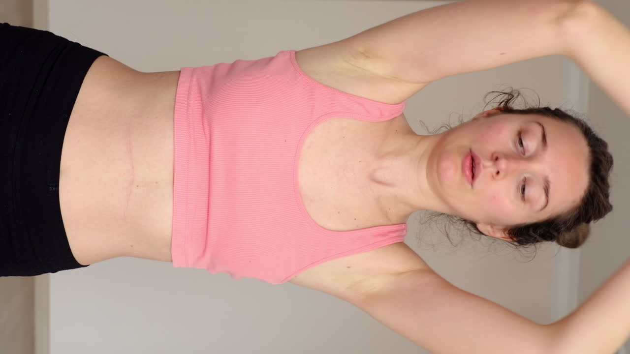 Woman in sportswear doing yoga at home. Vertical