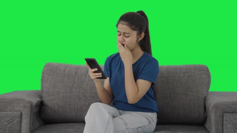 lazy indian teenage girl scrolling phone green screen