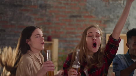 excited women clink bottles celebrating victory with buddies