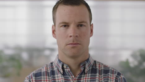 close-up-portrait-of-handsome-young-businessman-entrepreneur-looking-at-camera-serious-in-office-background