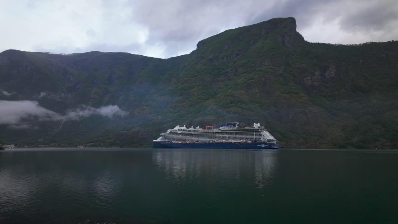 Celebrity Apex krydstogtskib sejler i Aurlandsfjorden med bjerge i baggrunden i Norge – bredt billede