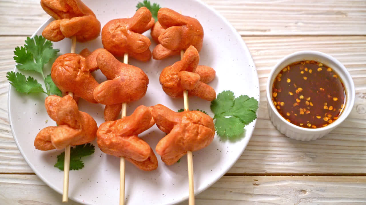 Brocheta de salchicha frita con salsa para mojar
