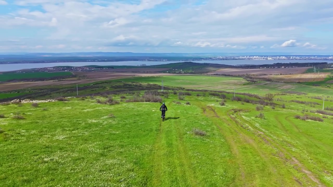 Vista aerea di un ciclista in mountain bike su una collina verde