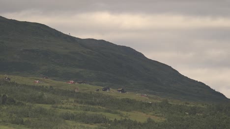 Lapso-De-Tiempo-Vespertino-De-Revhaugen-En-Myrkdalen-Noruega---Nubes-Y-Luz-Del-Sol-Pasando-Rápidamente-Sobre-El-Verde-Paisaje-Idílico-De-Montaña-Con-Casas-De-Vacaciones---Luz-Cálida-En-La-Tarde-Antes-Del-Atardecer