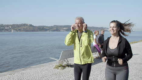 pareja deportiva corriendo juntos cerca del mar