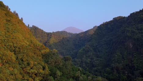 vuela sobre un acantilado empinado entre 2 colinas cubiertas de denso bosque