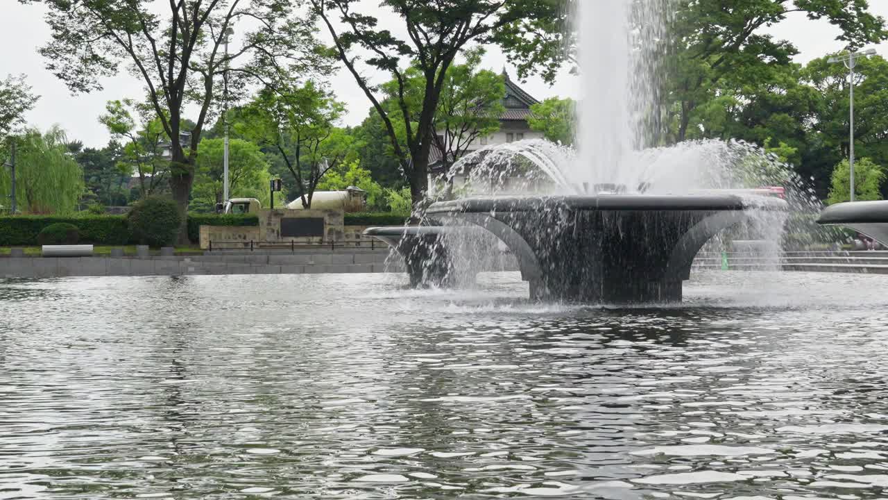 A serene fountain gracefully sprays water into a pool, creating a peaceful and refreshing scene in an outdoor setting.