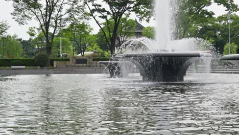 a serene fountain gracefully sprays water into a pool, creating a peaceful and refreshing scene in an outdoor setting.