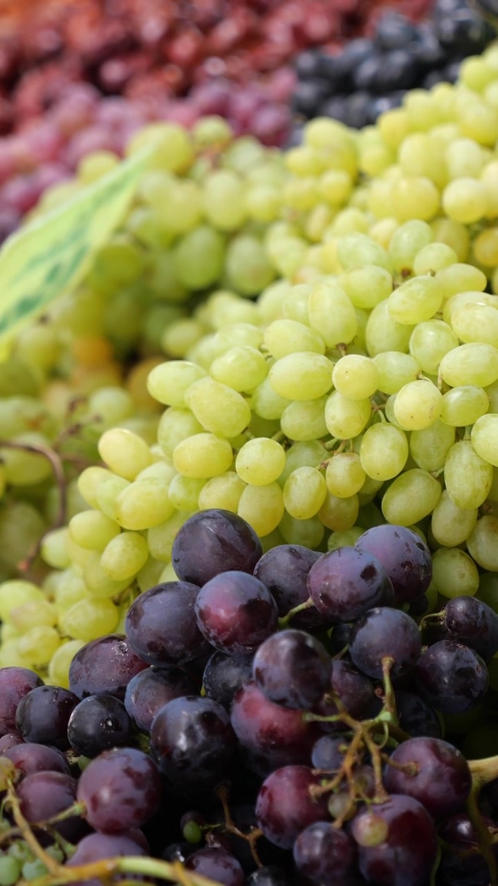 Uva fresca verde e viola in esposizione al mercato