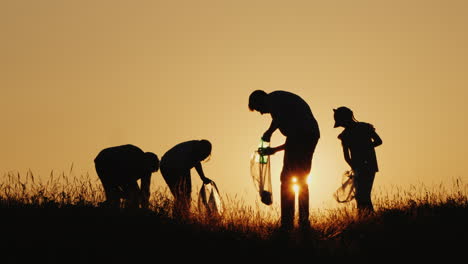 a group of people cleans up household garbage on a glade in a picturesque place clean environment co