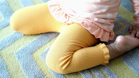 niña pequeña con leggings amarillos y camiseta rosa