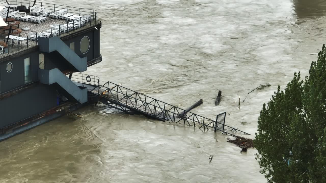 Aerial footage highlights a partially submerged restaurant on river