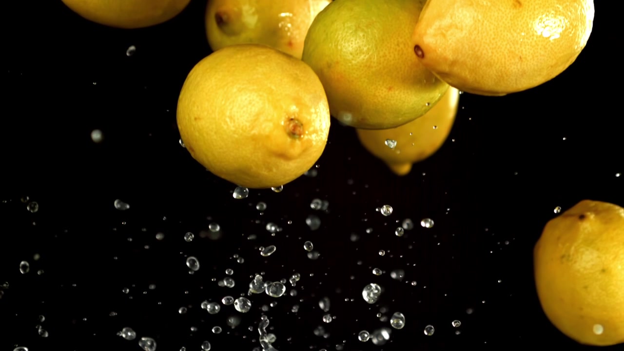 Limoni freschi con goccioline d'acqua che cadono al rallentatore