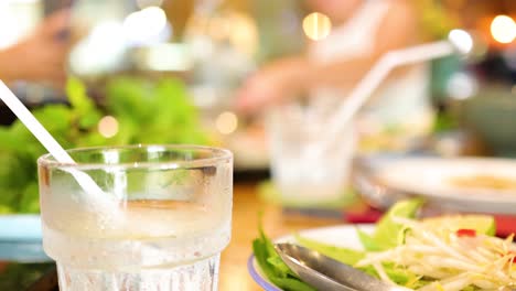a vibrant scene in a vietnamese restaurant with iced drinks and fresh dishes, capturing lively dining moments