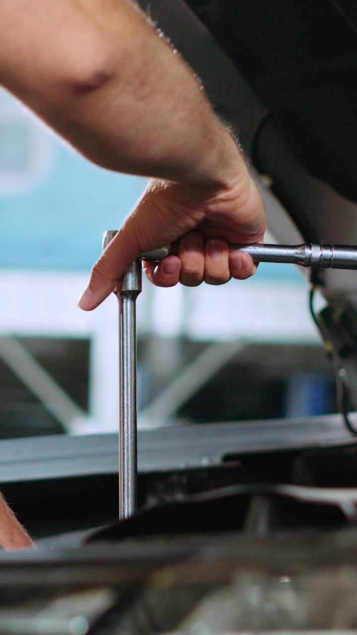 Vertical video Repairman in car service uses wrench