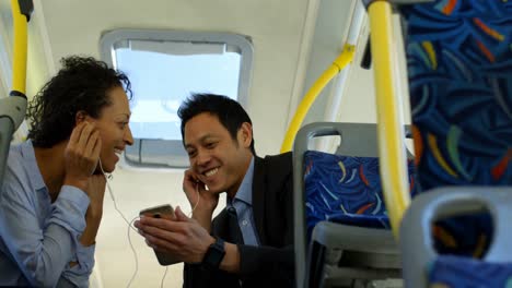 Couple-listening-music-on-mobile-phone-while-travelling-in-bus-4k