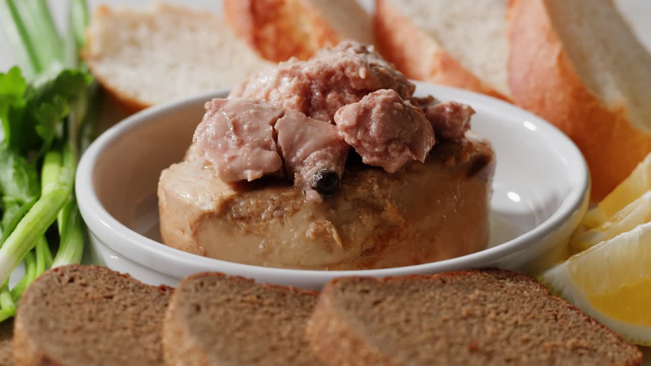 Smoked cod liver in oil in open tin can with fresh greens on wooden table. Seafoods delicacy. High quality 4k footage