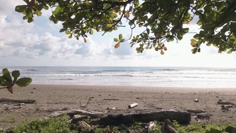 a view of the ocean waves crashing the shore in dominical beach in costa rica, static wide shot