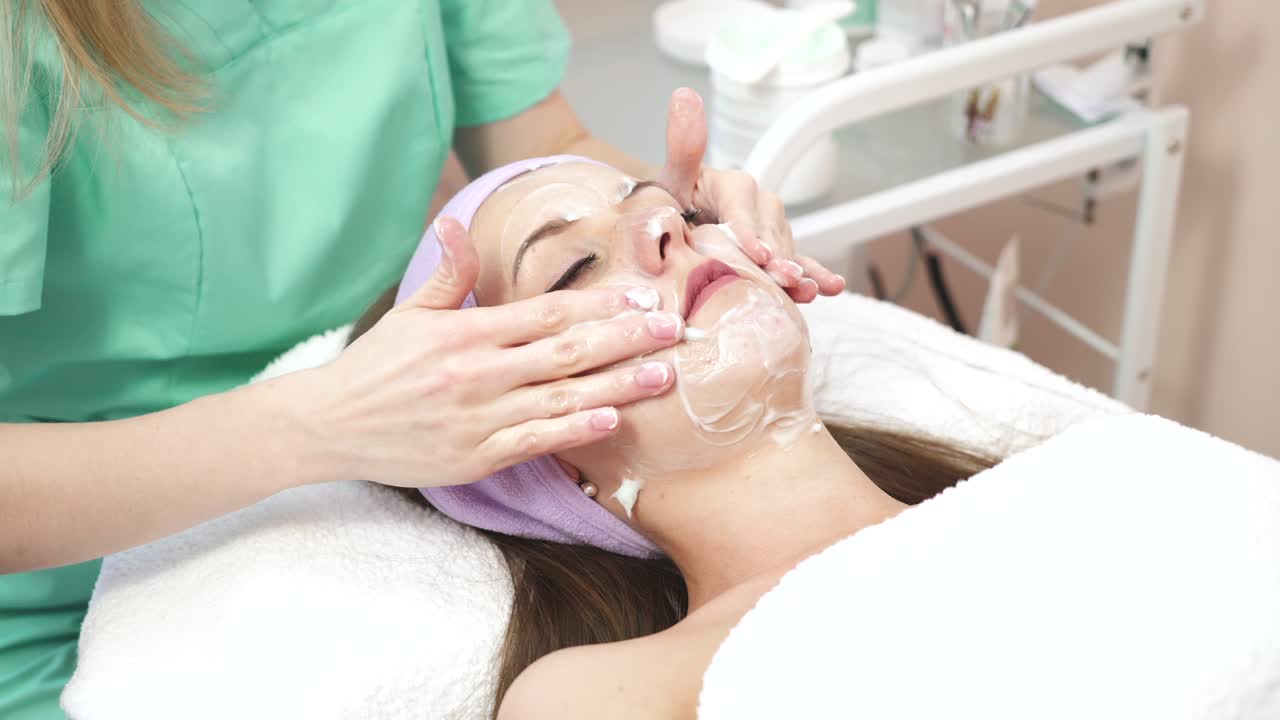 Woman during facial massage. Young woman relaxing during rejuvenating facial massage in beauty center