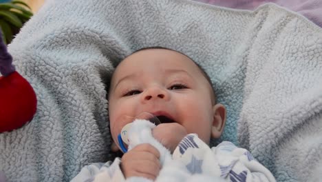 cute tree months old shy smile while sitting in baby bouncer