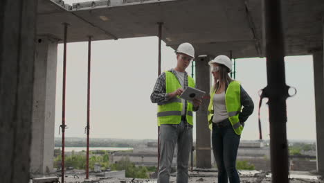 engineers or architects have a discussion at construction site looking through the plan of construction. contre jour. engineers or architects have a discussion