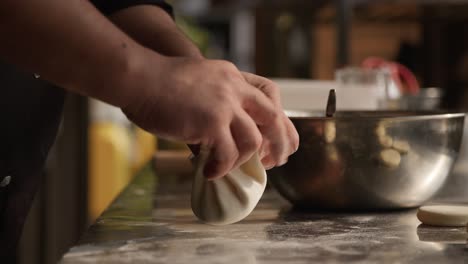 Homemade-khinkali-dumplings,-traditional-georgian-food,-closeup-on-hands