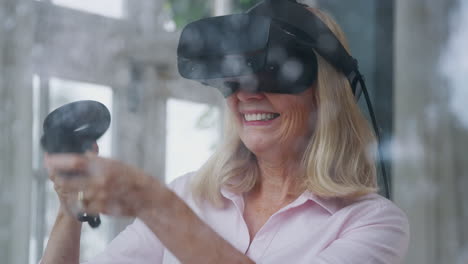 View-Through-Window-As-Mature-Woman-Wears-Virtual-Reality-Headset-And-Holds-Gaming-Controllers