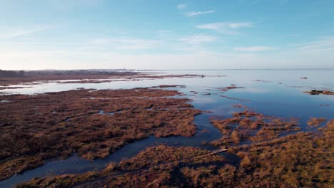 Hermoso-Lago-Masivo-Y-Coloridos-Humedales,-Toma-Aérea-De-Drones