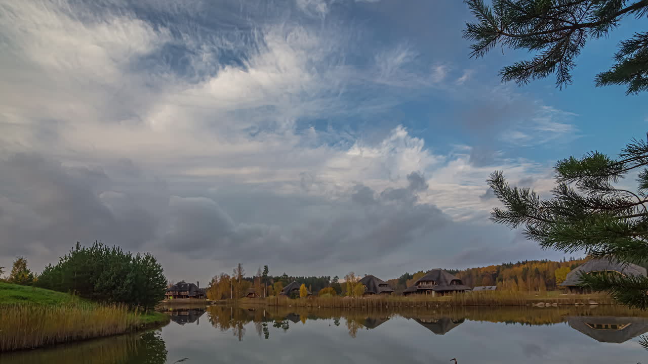 toma de tiempo del movimiento de la nube sobre filas de cabañas al lado de un lago en la distancia durante la noche