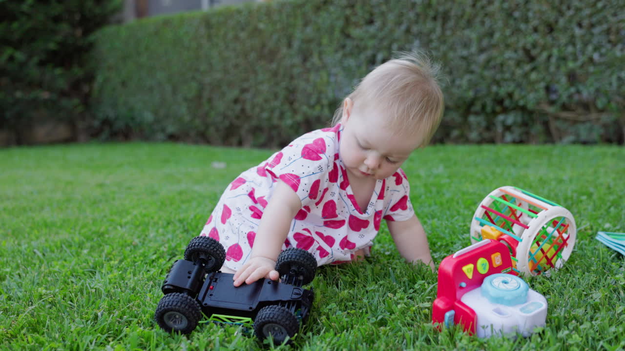 Happy Baby Playing with Toy Car on Green Lawn