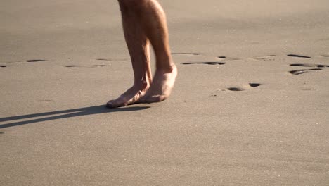 Close-up-of-male-feet-walking-on-beach