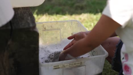 niño comprobando si las manos se lavan correctamente en el agua