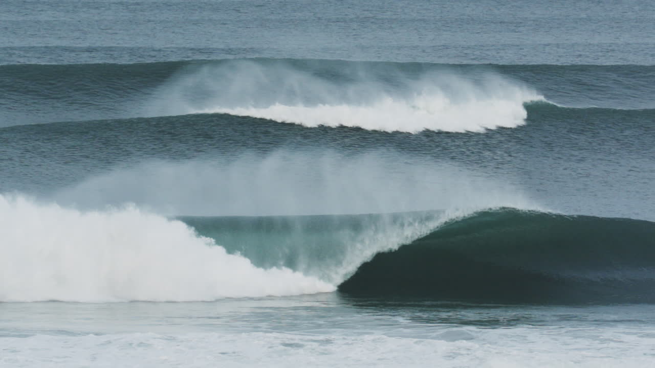 Side view of barreling surf wave with foam detail and energy