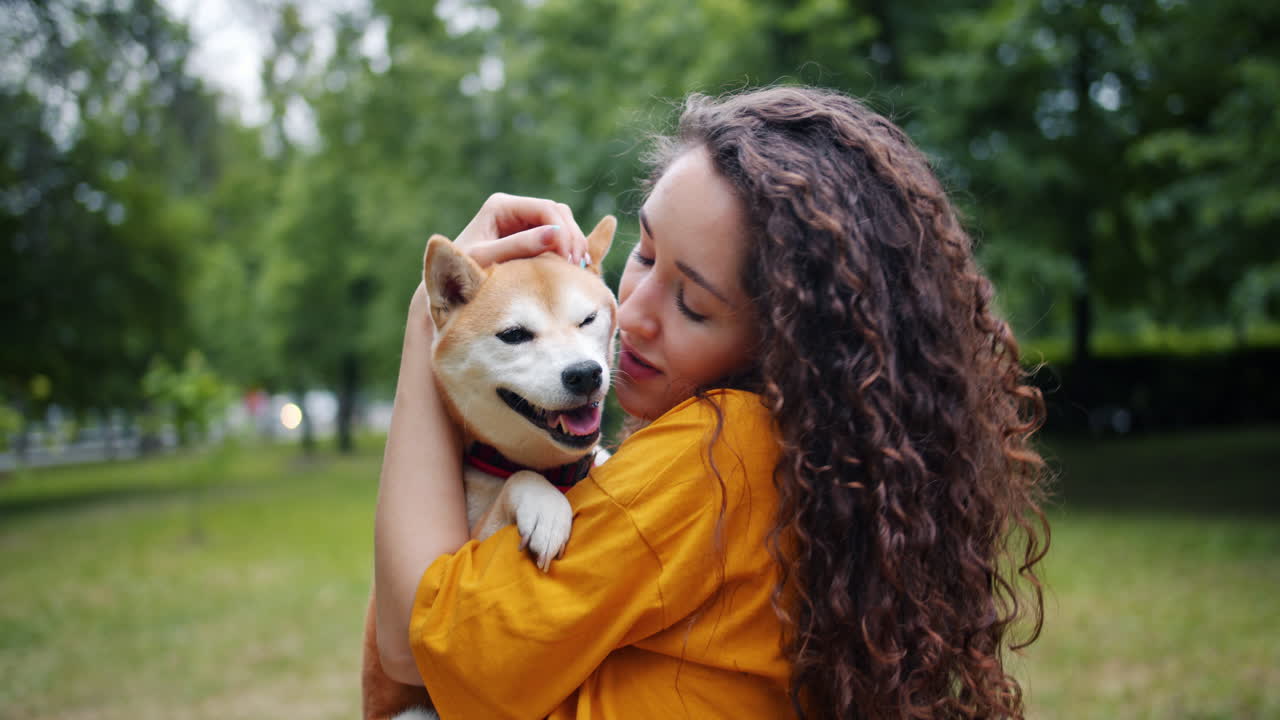 Woman Kissing a Shiba Inu Dog in a Park