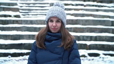 woman in winter outfit looking up at snow covered steps