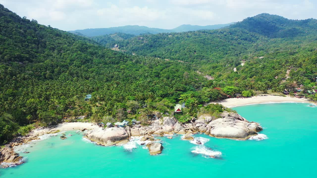 Peaceful sea panorama with turquoise lagoon and white waves splashing on cliffs and sandy beach of tropical island