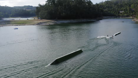 men enjoying teleski in the deep peaceful ocean during daytime - aerial shot