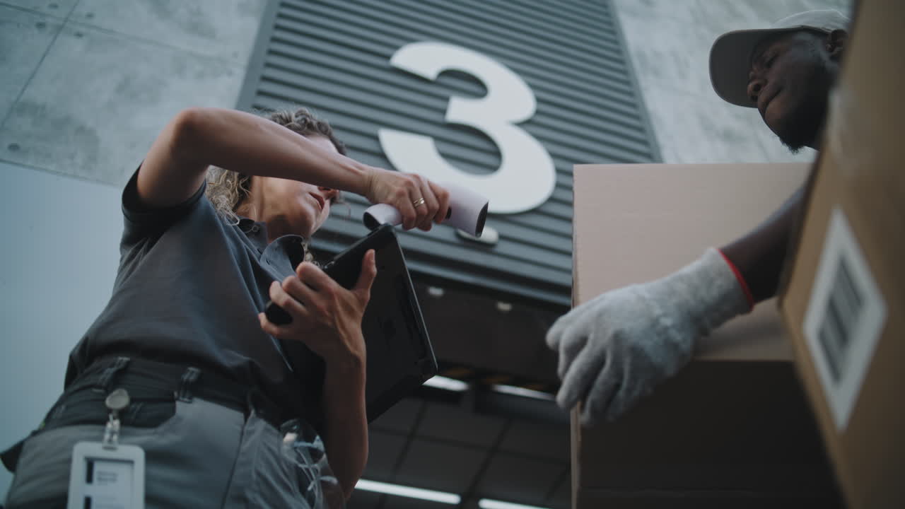 Delivery Worker and Courier Processing a Package at a Warehouse