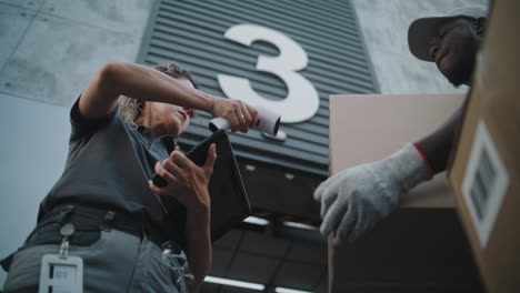 delivery worker and courier processing a package at a warehouse