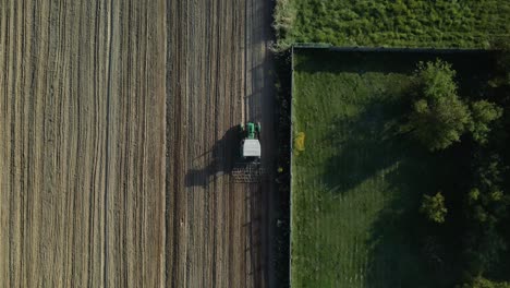 Antena-De-Arriba-Hacia-Abajo-Del-Tractor-Arando-El-Campo-Agrícola-En-Polonia-Durante-La-Luz-Del-Sol