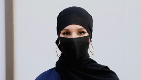 woman on flu face mask protecting from covid19 corona virus during pandemic, wearing burqa shayla and hijab