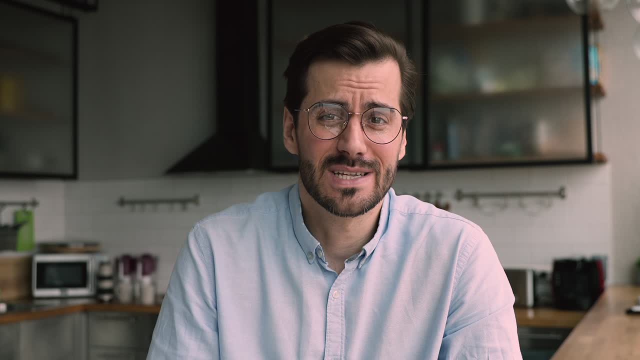 hombre de negocios sentado en la cocina hablando con el cliente remotamente usando videocall