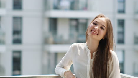 young woman smiling on a balcony