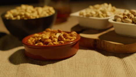 close up of bowls of cashews dry roasted peanuts and pistachio nuts in studio