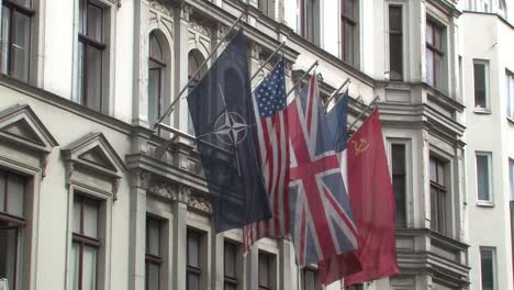 Medium-shot-of-flags-at-Haus-am-Checkpoint-Charlie-near-former-border-crossing-Checkpoint-Charlie-in-Berlin,-Germany