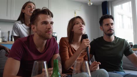 un grupo de amigos cantando karaoke en casa.