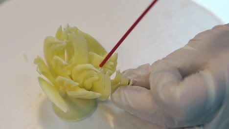 confectioner prepares cake decoration element with tubule