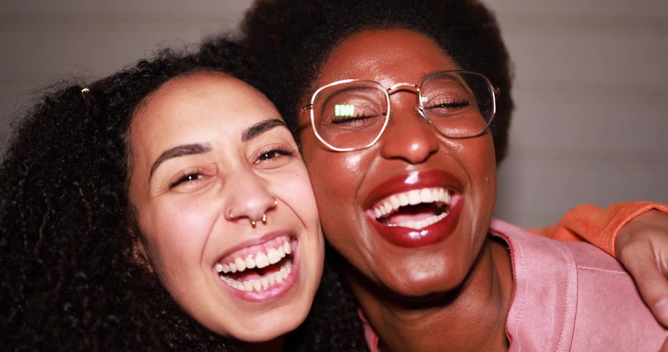 Deux femmes diverses et joyeuses riant de bon cœur ensemble